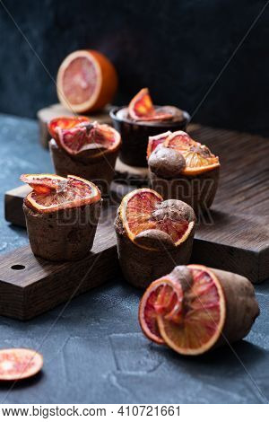 Blood Oranges Choco Muffins Close Up At Dark Oak Cutboard On Dark Cocrete Background