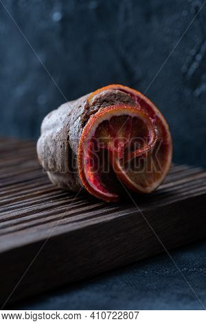 Choco Muffin With Blood Orange Slices On Ribbed Oak Cutboard Close Up On Dark Background