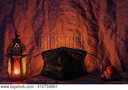 Black Fack Mask, Lantern And Dates Fruit On Dark Cloth Background For The Muslim Feast Of The Holy M