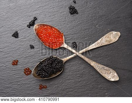 Black Caviar Of Paddlefish Fish And Red Chum Salmon Caviar In A Spoon, Black Background, Top View