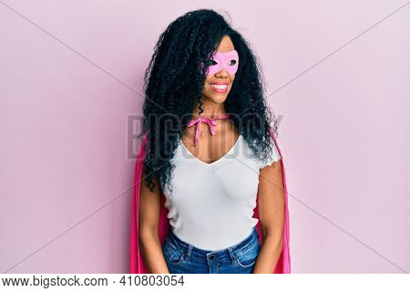 Middle age african american woman wearing super hero costume smiling looking to the side and staring away thinking. 