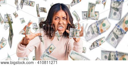 Young beautiful mixed race woman wearing winter turtleneck sweater shouting frustrated with rage, hands trying to strangle, yelling mad