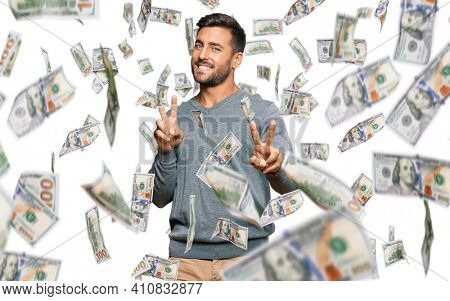 Handsome hispanic man wearing casual clothes smiling looking to the camera showing fingers doing victory sign. number two.