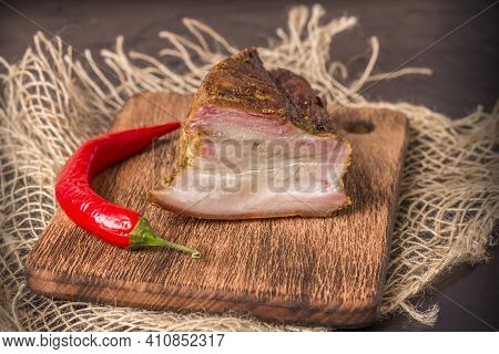 A Piece Of Baked Meat With Layers Of Bacon, Cut From The Bottom Of A Pork Carcass, Along With The Sk