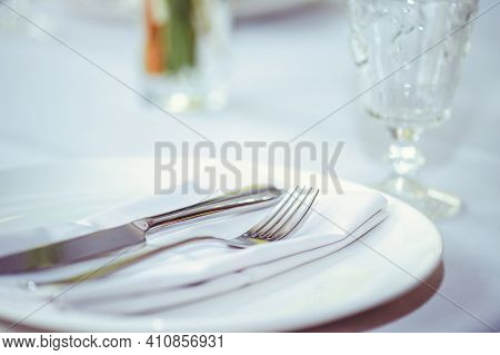 Restaurant Table Setout With White Plates And Silverware