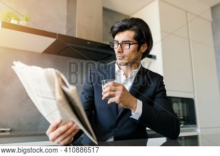 Businessman Read News From A Newspaper While Drinking A Coffee At Home