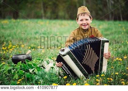 A Boy In Military Uniform On The Holiday Of May 9 Plays The Accordion