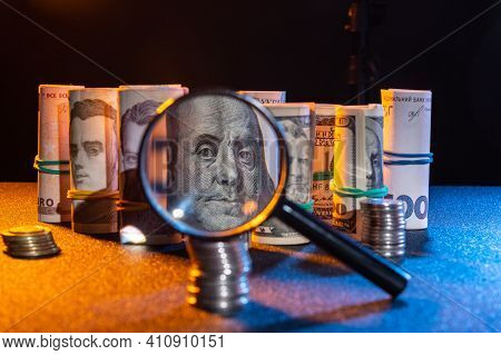 Checking Money For Falsity. Examining Money Through A Magnifying Glass.