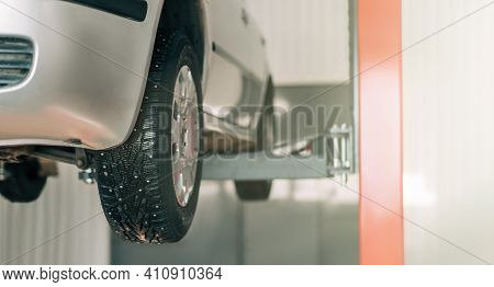 The Machine Is Lifted On A Car Lift For Repair. Side View Of The Car