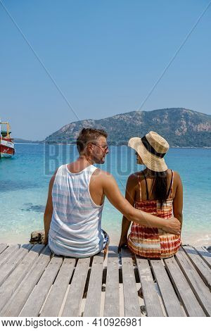 A Couple From Behind On The Backside Looking Out Over The Ocean Of Tropical Island, Men And Woman Va