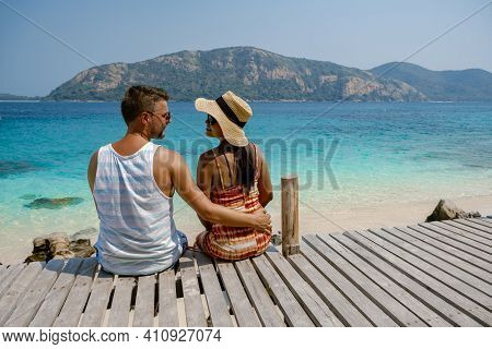 A Couple From Behind On The Backside Looking Out Over The Ocean Of Tropical Island, Men And Woman Va