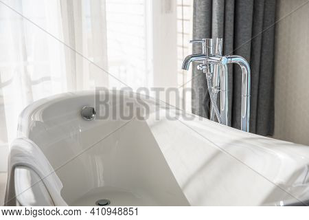 Old Style Bath Tub In Elegant Luxury Resort Bathroom. Sunny Window View Over. White Interior Bathtub