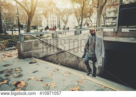 A Dapper Mature Bald Black Man Entrepreneur In A Fashionable Custom Plaid Costume And A Coat, With A