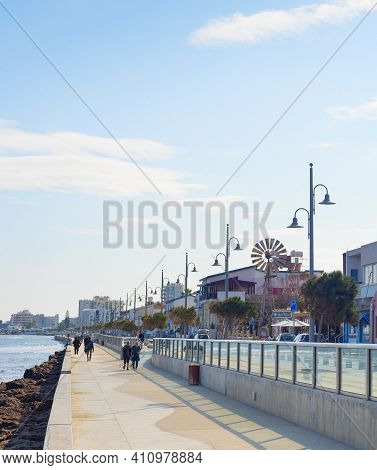 Larnaka, Cyprus - Feb 18, 2019: People Walking By Larnaca City Embankment With Typical Architecture 