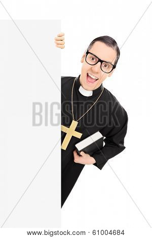 Catholic reverend standing behind blank panel isolated on white background