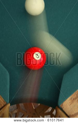 Green pool table with cue ball in motion 