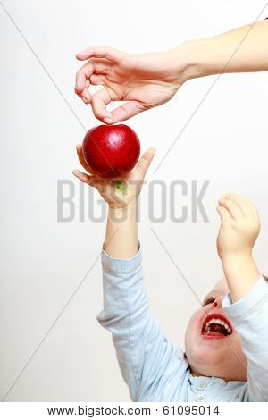 Happy Childhood. Boy Child Kid Reaching For Apple Fruit. At Home.