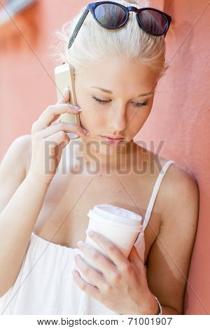 Serious young woman talking on the phone outdoors