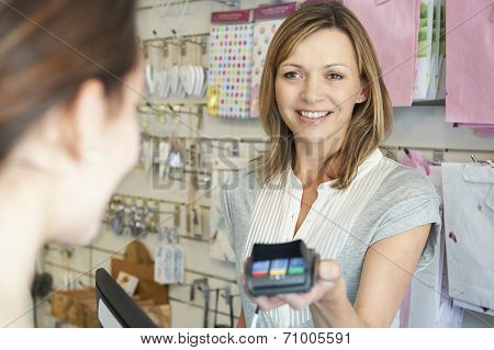 Shopper Paying For Goods Using Credit Card Machine