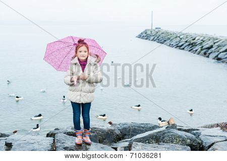 Little girl with umbrella on a rainy day