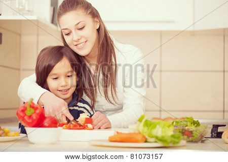 Mother and son preparing food in kitchen together