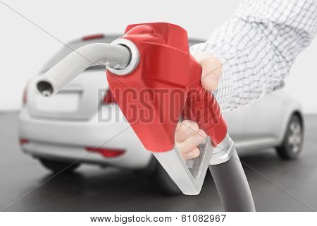 Red Color Fuel Pump Gun In Hand With Grey Car On Background