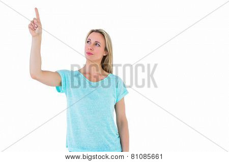 Pretty blonde thinking and pointing up on white background