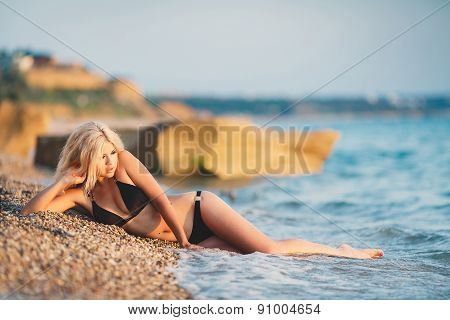 Portrait of happy sexy girls in bikini posing on the background of the sea