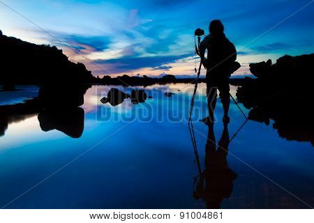 Silhouette of Photographer taking sunset/sunrise with reflection