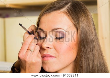 Makeup artist paints the eyebrows model. painting of eyebrows.