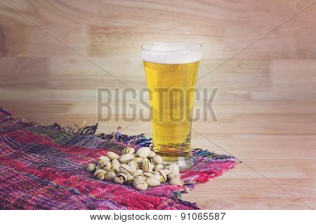Glass Beer And Pistachios On Wood Background