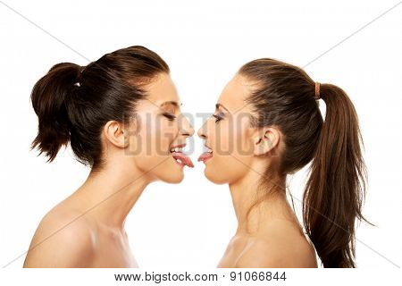 Two attractive women with make up showing their tongs.