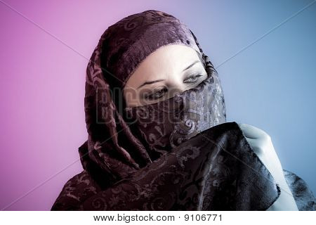Arabiska beslöjad kvinna klädd lyser med två lampor, rosa och blått