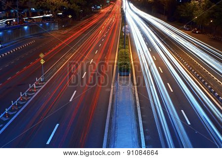 Long exposure photo of traffic with blurred traces from cars top view.