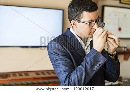 Jeweler examining diamond thoroughly through loupe jewel