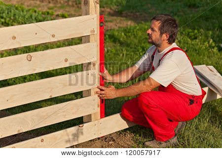 Man Building Wooden Fence