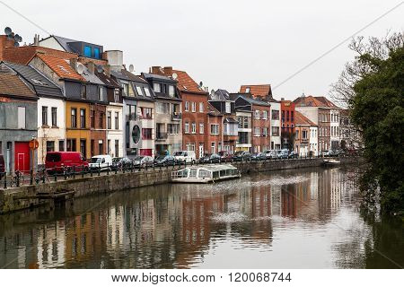 GHENT BELGIUM - 18TH FEBRUARY 2016: A view of buildings along the River Leie and Achterleie street during the day. Boats can be seen.