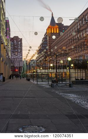 Empty  square with evening illumination and occasional passers-by