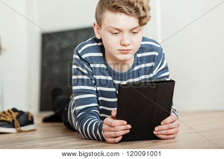 Boy Lying On Floor With Tablet Computer