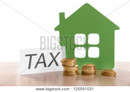 House figure, coins and tax sign, closeup