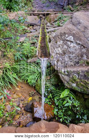 Selective Focus On Water From Bamboo Stream Way From The Waterfall.