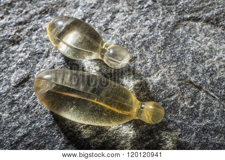 Gel capsules on a stone background