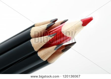 Black pencils with a red one in the middle