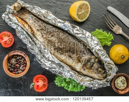 Grilled sea bass fish on the gray table.