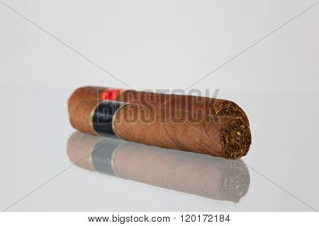 Different cigars on a glass table and white background