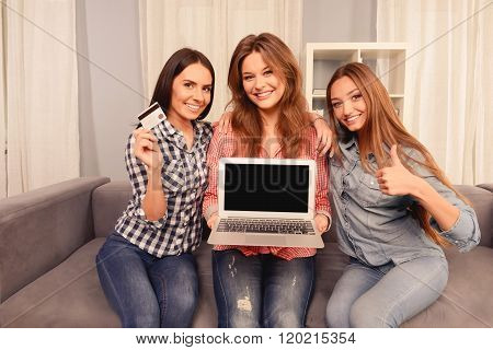 Cheerful Girls Showing Laptop, Bank Card And Gesturing