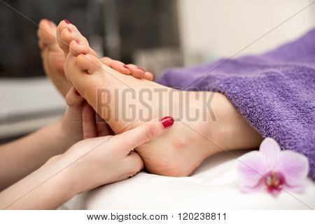 Woman Having A Pedicure Treatment At A Spa Or Beauty Salon With The Pedicurist Massaging Feet.