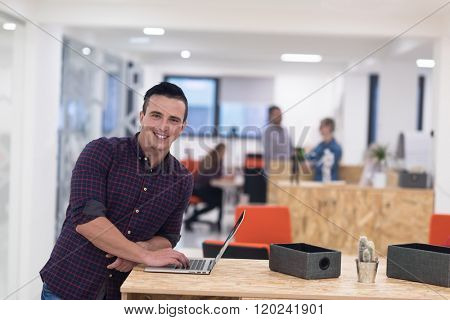 portrait of young businessman in casual clothes at modern  startup business office space,  working on laptop  computer