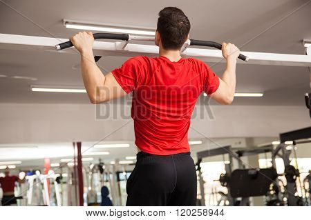 Athletic Man Doing Pullups At A Gym
