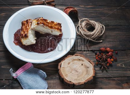 Berry drink. Saucer kissel with cheese casserole and spices on wood